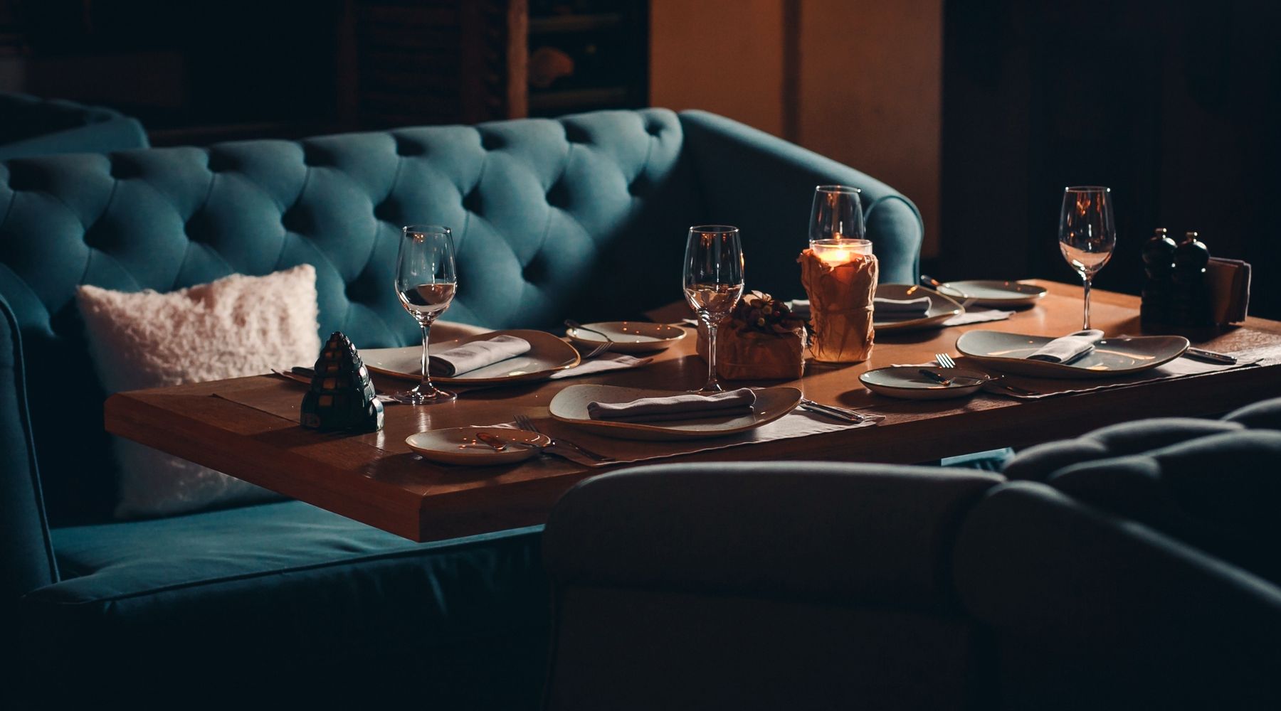 A table set for guests with wine glasses in a warm dining room